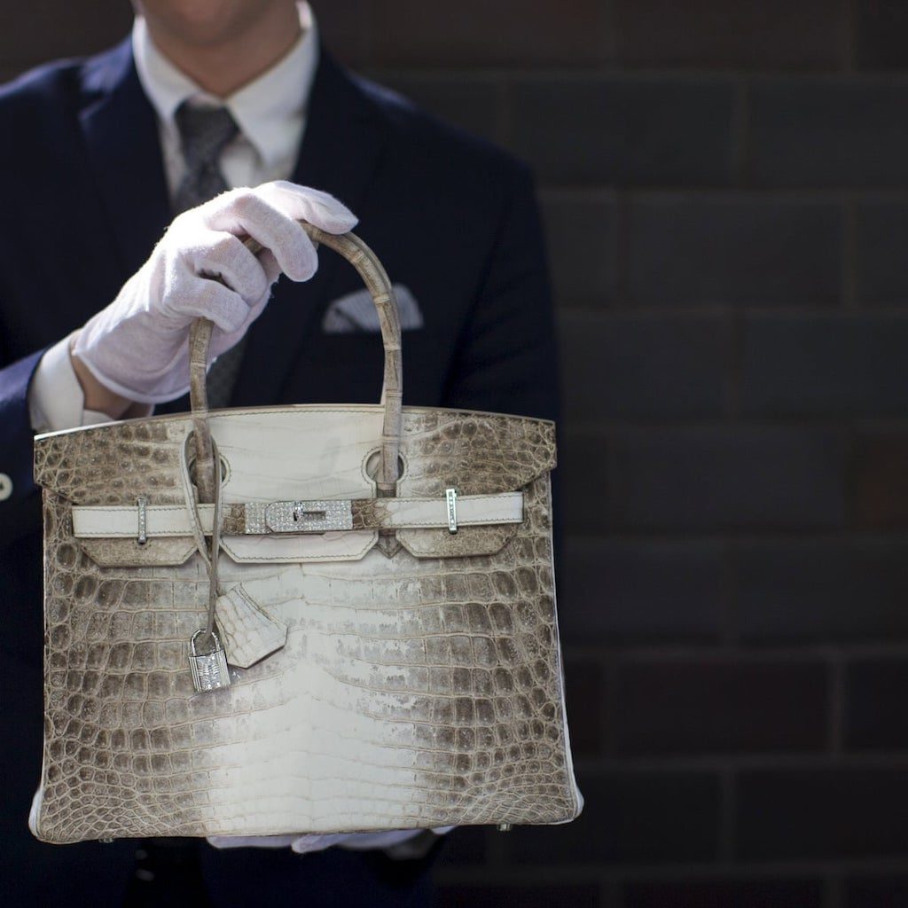 A woman inspects Hermes crocodile skin bag in Taipei on April 10